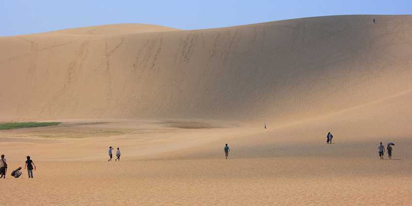  People walking across the sand dunes in Tottori, Japan